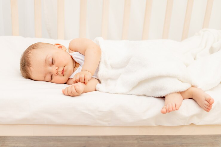 Foto klein babymeisje 6 maanden oud die in een wit bed, gezonde babyslaap slapen