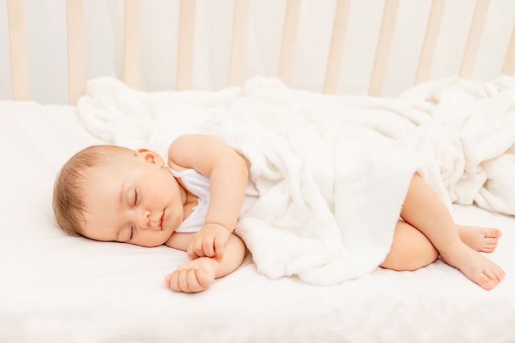Foto klein babymeisje 6 maanden oud die in een wit bed, gezonde babyslaap slapen