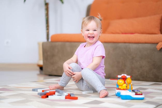 Klein babymeisje dat kleur houten speelgoed speelt thuis zittend op de vloer vroeg onderwijs