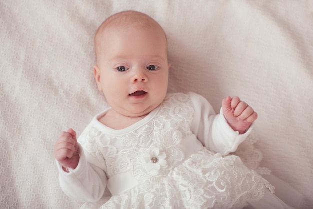 Klein babymeisje die prinsessenkleding dragen die in bed liggen