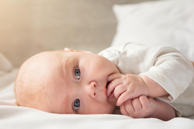 Klein babymeisje ligt op buik op ouderbed