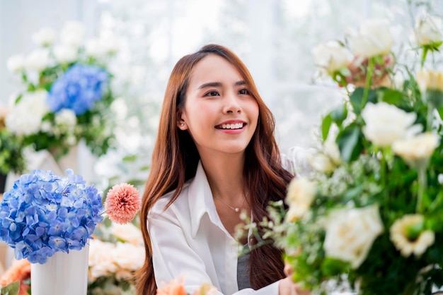 Klein bedrijf azië vrouwelijke bloemist glimlacht bloemen schikken in bloemenwinkel bloemontwerp winkelgeluk glimlachende jonge dame die bloemenvaas maakt voor klanten die bloemwerk voorbereiden vanuit huiszaken