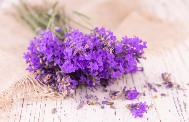 Klein boeket van delicate lavendelbloemen op een witte houten oude achtergrond