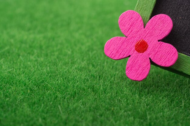 Klein bord met een bloem erop op groen gras