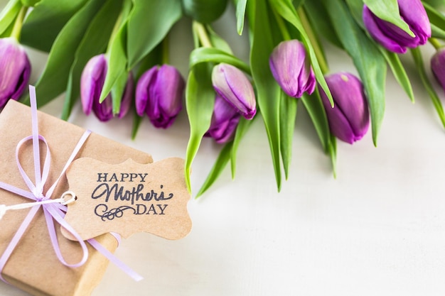 Klein cadeautje en paarse tulpen voor Moederdag.