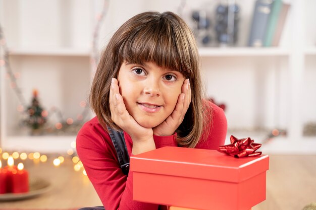 Klein donkerbruin meisje lacht blij voor Kerstmis