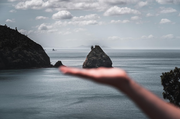 Foto klein eiland vastgehouden door een menselijke hand in nieuwe vrienden