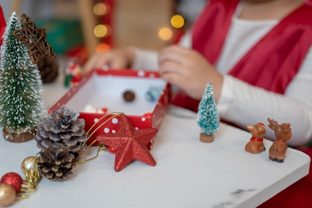 Klein gelukkig Aziatisch meisje veel plezier op kerstfeest in de woonkamer met decoratie thuis.