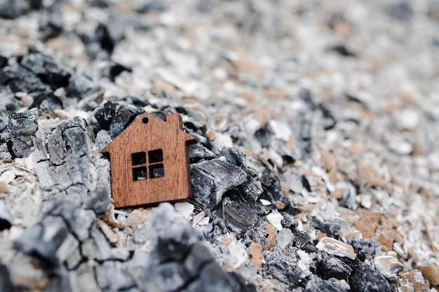 Foto klein houten huis op een as vuurconcept