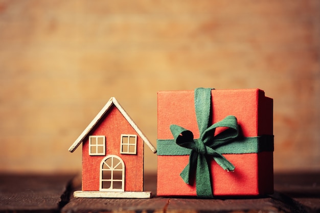 Klein houten huis speelgoed en geschenkdoos op een tafel