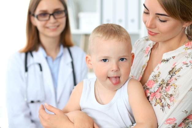 Klein jongenskind met zijn moeder na gezondheidsonderzoek bij de dokter