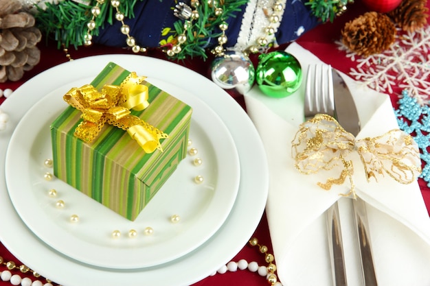 Klein kerstcadeau op bord bij het serveren van kersttafelachtergrond close-up