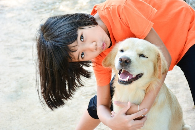 Foto klein kind aziatisch meisje knuffel haar hond