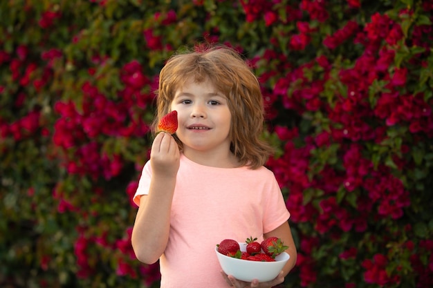 Klein kind dat aardbei eet in de natuur kind geniet van een heerlijke bes