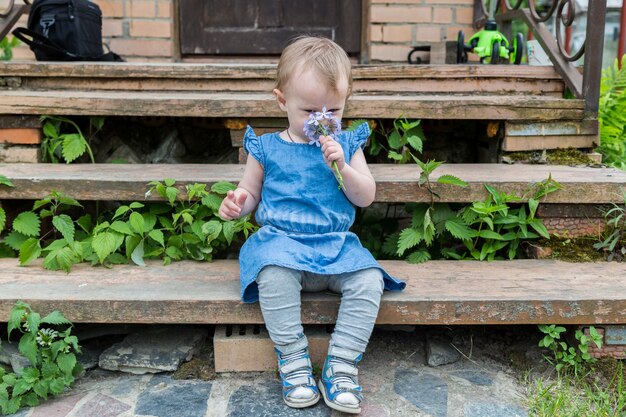 Klein kind dat een bloem ruikt