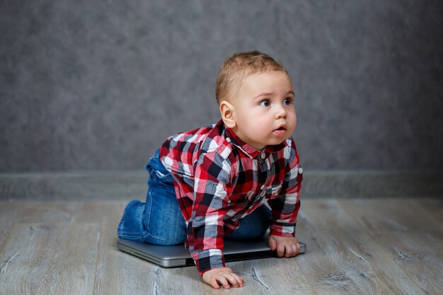 Klein kind in shirt speelt met laptop