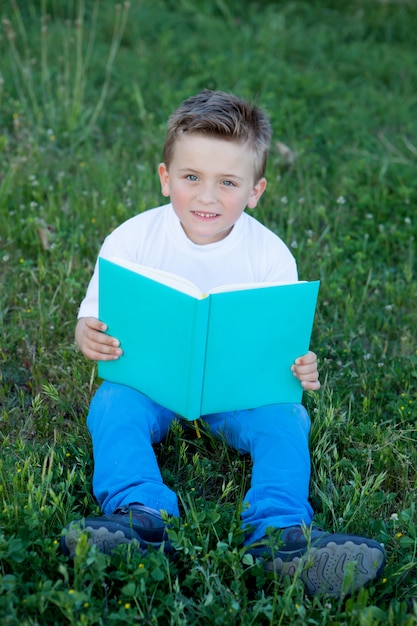 Klein kind lezen van een boek aan de buitenkant