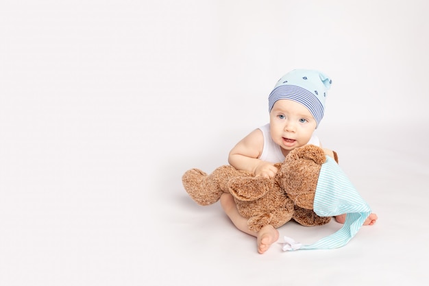 Klein kind met een teddybeer op een witte geïsoleerde achtergrond