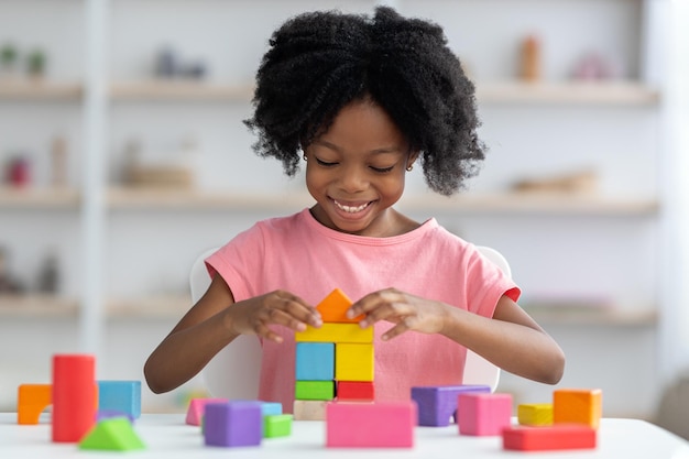 Klein kind speelt met kleurrijke houten blokken