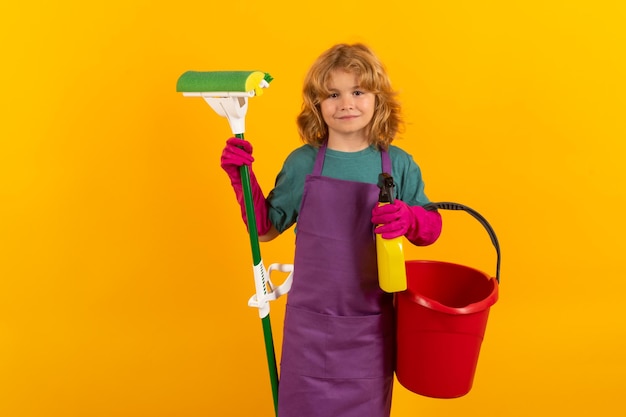 Klein kind thuis schoonmaken Kind doet huishoudelijk werk met plezier Studio isoalted portret van kinderhuishoudster met natte platte dweil op gele achtergrond