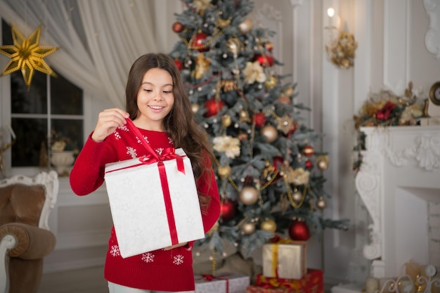 Klein kindmeisje houdt van kerstcadeau. De ochtend voor Kerstmis. Nieuwjaar vakantie. Kerstmis. Kind geniet van de vakantie. Gelukkig nieuwjaar. klein gelukkig meisje met Kerstmis. Kerst plezier. Feest van Kerstmis.