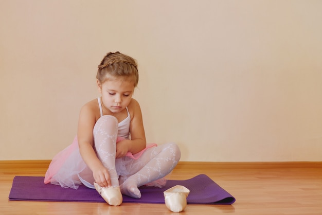 Klein kindmeisje met pointe-schoenen en roze tutu rok