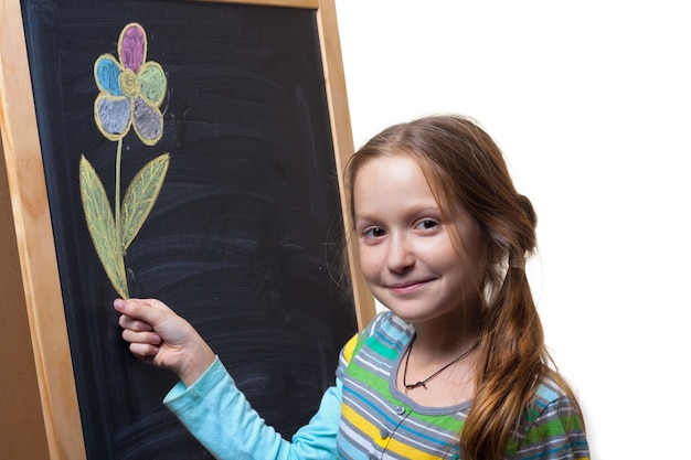 Klein lachend meisje met een bloem die met krijt op een schoolbord is getekend