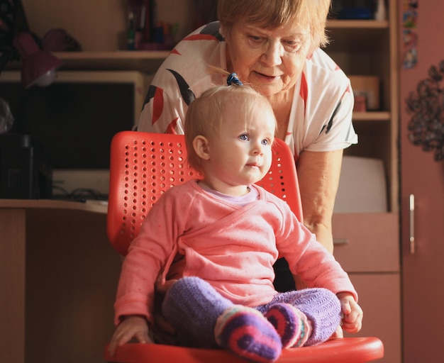 Klein lief meisje speelt thuis met oma, telefoto-opname