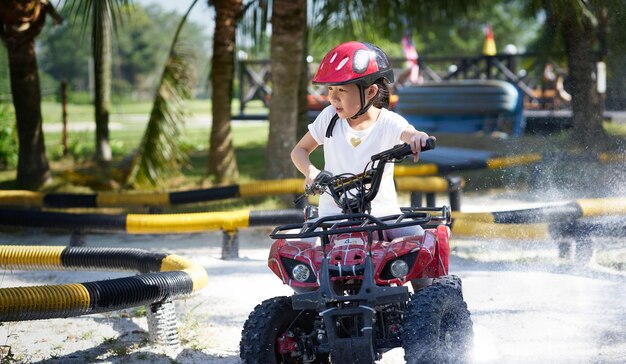 Klein meisje ATV quad rijden in racebaan.