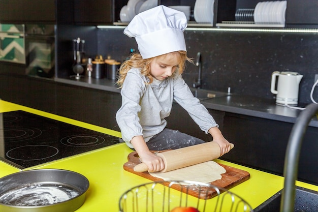 Klein meisje bereidt deeg bak zelfgemaakte vakantie appeltaart in de keuken