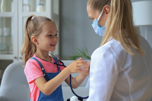 Klein meisje bij de dokter voor een controle. Kind ausculteer de hartslag van de arts.