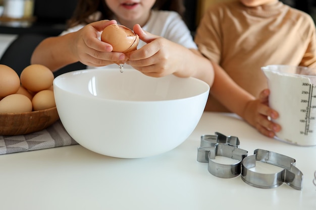 Klein meisje breekt een ei close-up koken masterclass