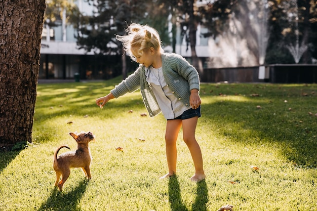 Klein meisje buiten spelen met een puppy