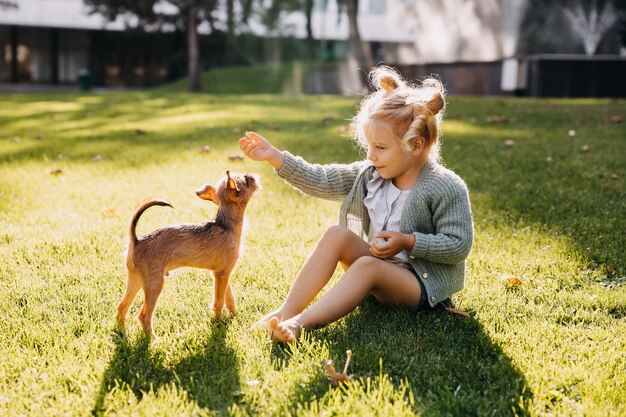 Klein meisje buiten spelen met een puppy