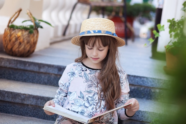 Klein meisje dat een boek leest over stappen van het huis kind leert lessen na school