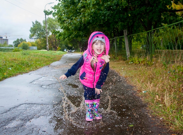 Klein meisje dat in plassen springt