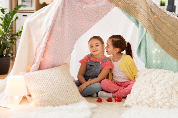 klein meisje dat theepartij speelt in een tent voor kinderen thuis