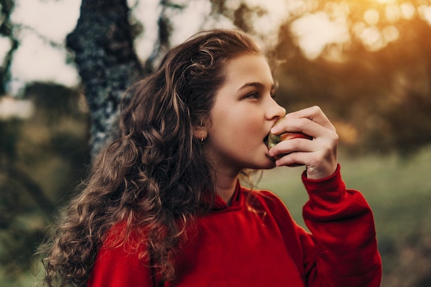 Klein meisje dat verse appel eet in de natuur