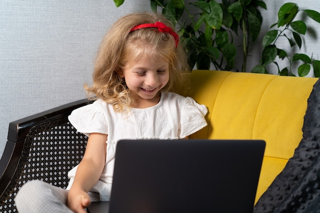 Klein meisje doet thuis lessen op een laptop