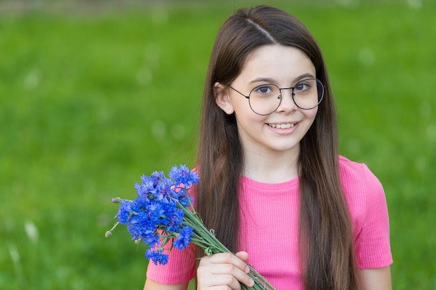 Klein meisje draagt vintage rand brillen groen gazon achtergrond zomervakantie concept