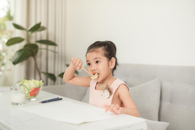 Klein meisje eet groene groentemaaltijd