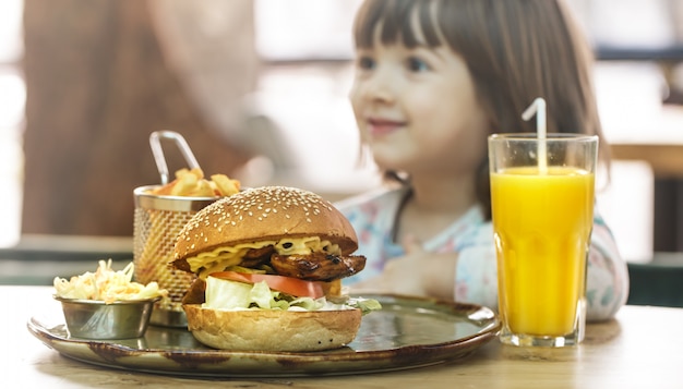 Klein meisje eet in een fastfood-café