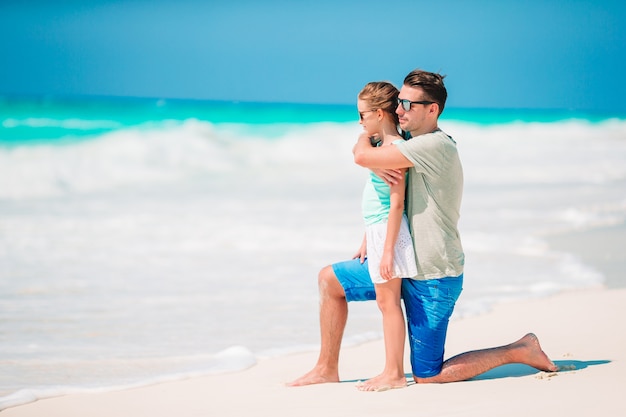 Klein meisje en gelukkig vader plezier tijdens strandvakantie