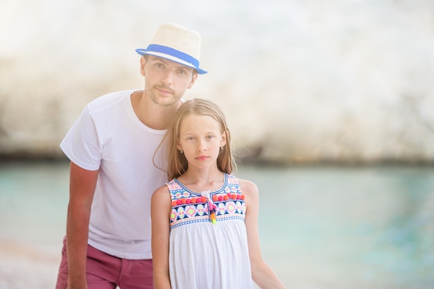 Klein meisje en gelukkig vader plezier tijdens strandvakantie