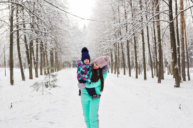 Klein meisje en haar moeder hebben plezier op een winterdag.