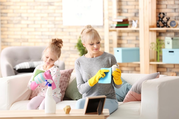 Foto klein meisje en haar moeder maken thuis schoon