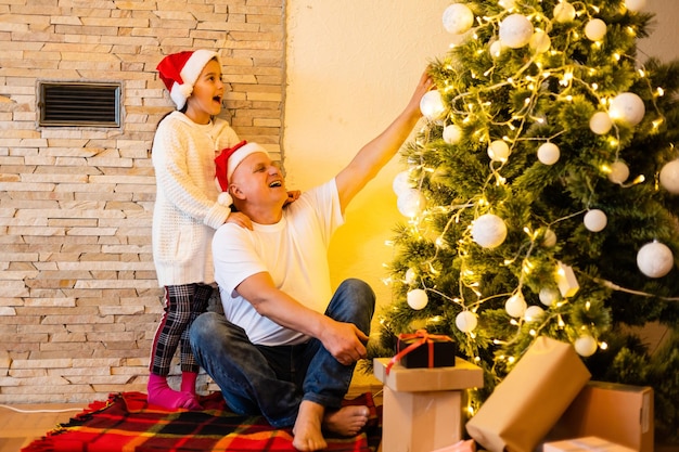 Klein meisje en haar opa met kerstcadeau in huis