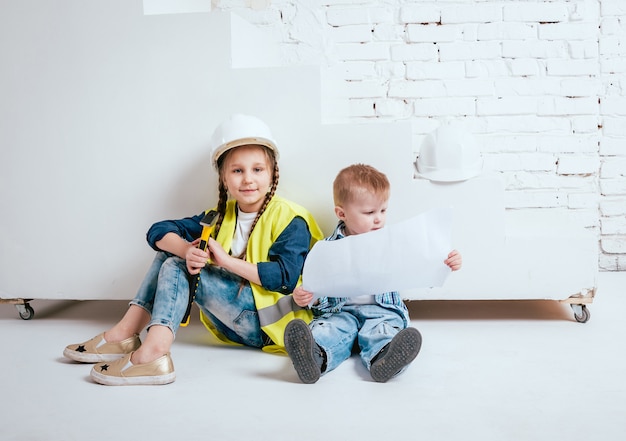 Klein meisje en jongen op de witte muur. Bouw