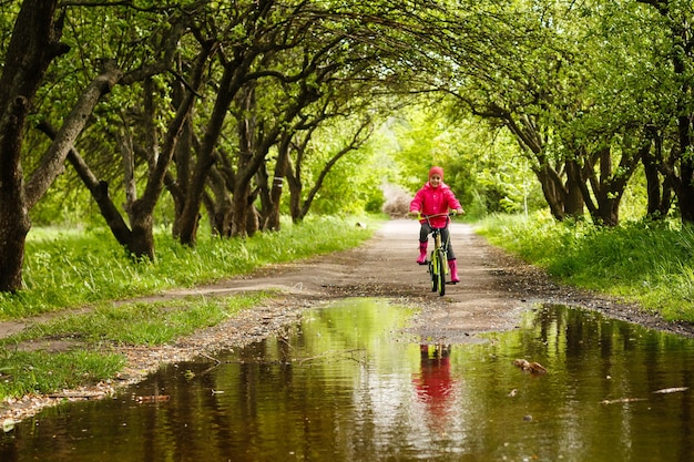 Klein meisje fietst in waterplas