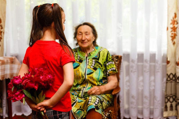 klein meisje geeft haar overgrootmoeder een roze bloem